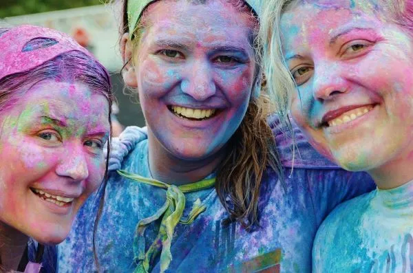 A photo of three women smiling after a colorful activity