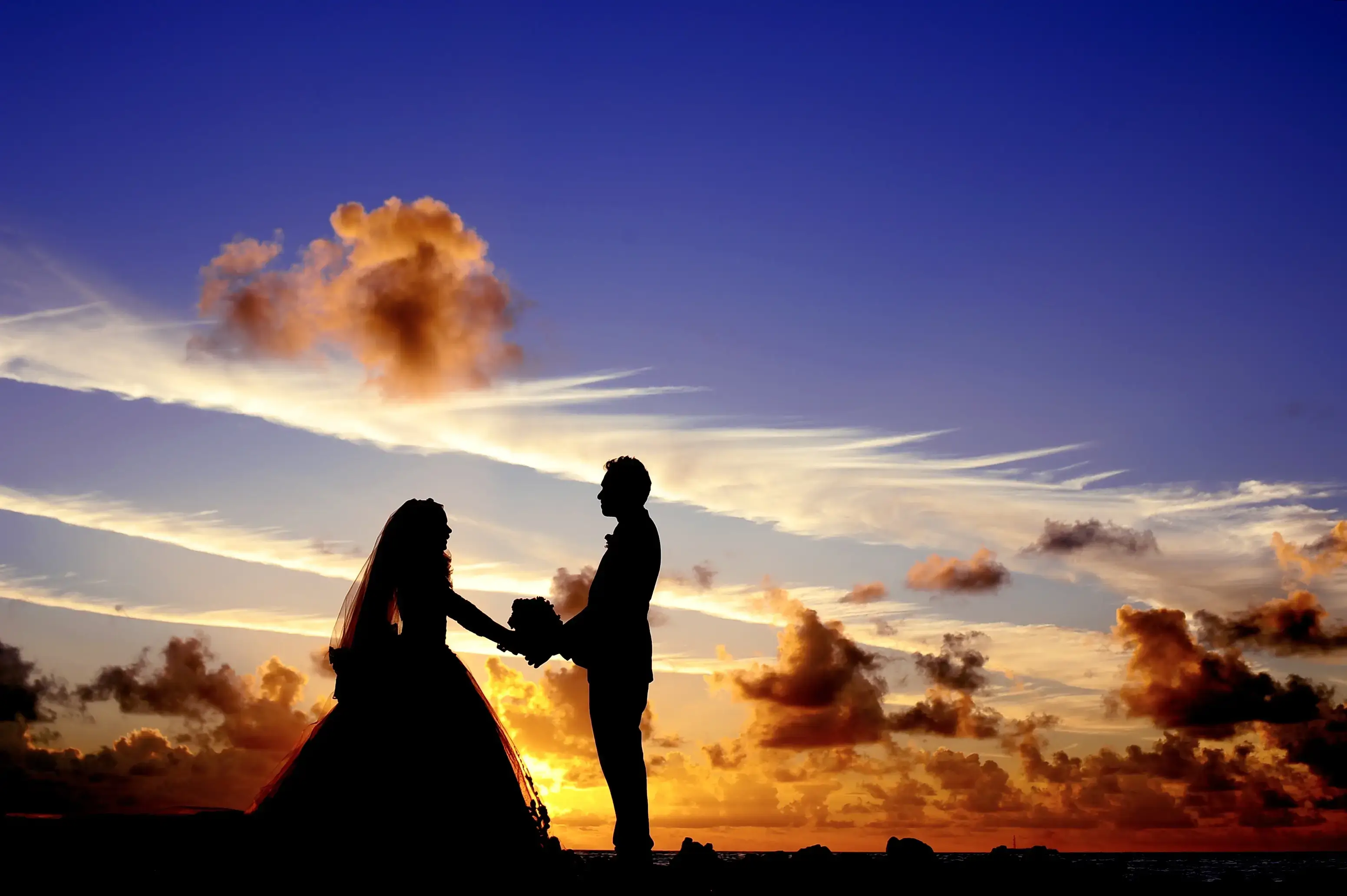 A couple wearing wedding clothes during sunset